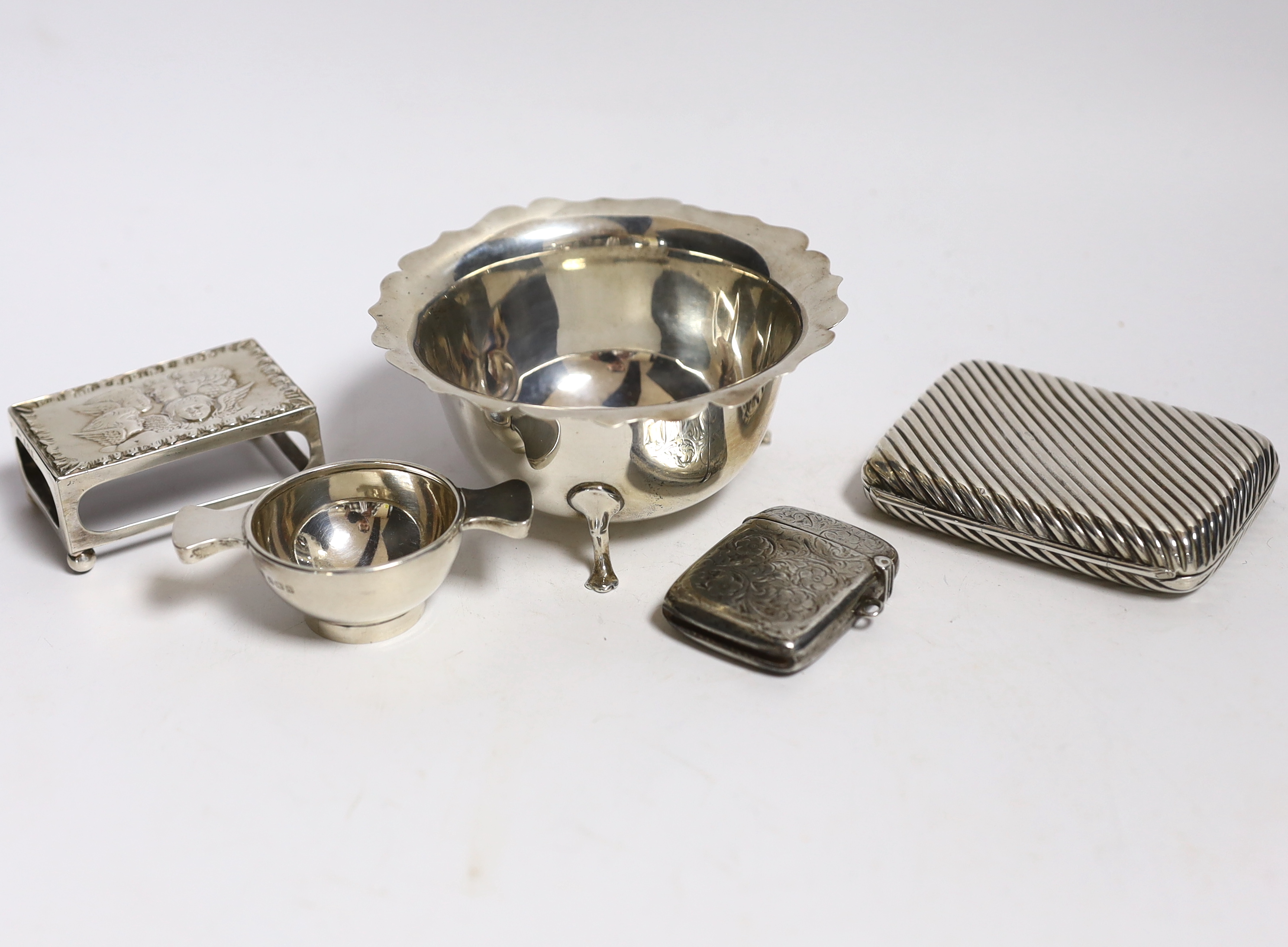 A silver cigarette case, small silver quaich, silver bowl and silver matchbox sleeve.